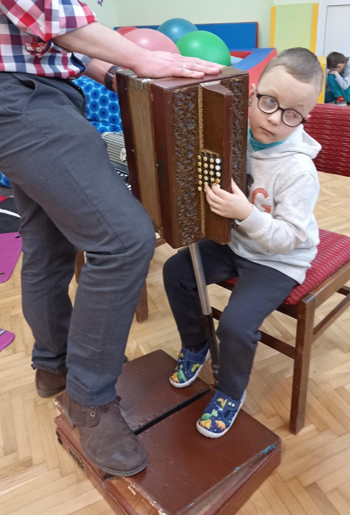 Matviey z pomocą naszego gościa gra na harmonii