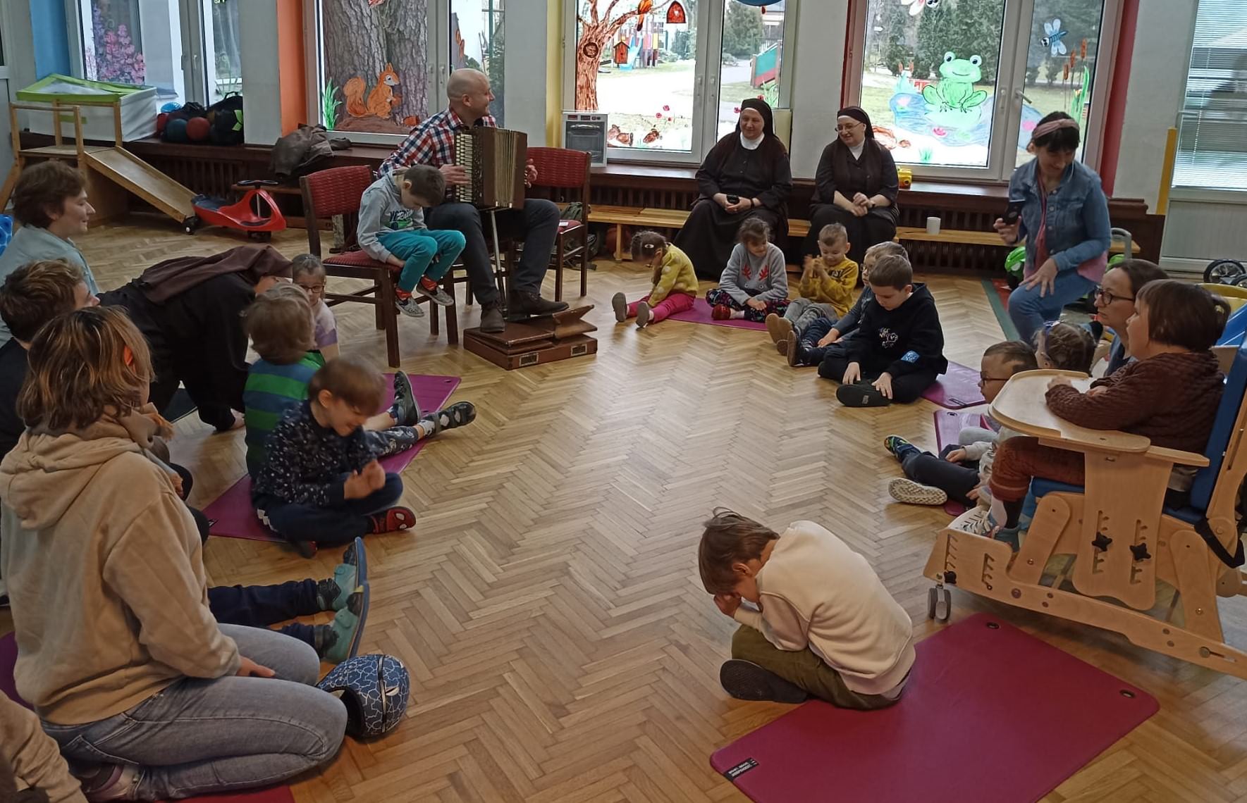 Uczestnicy spotkania słuchają muzyki granej przez naszego gościa