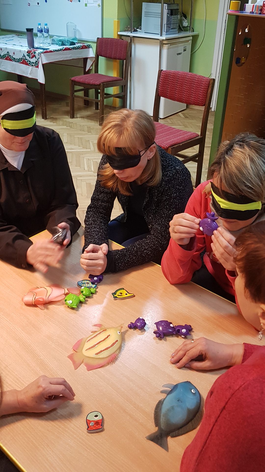 Nauczyciele w opaskach na ocz ach oglądają modele rybek