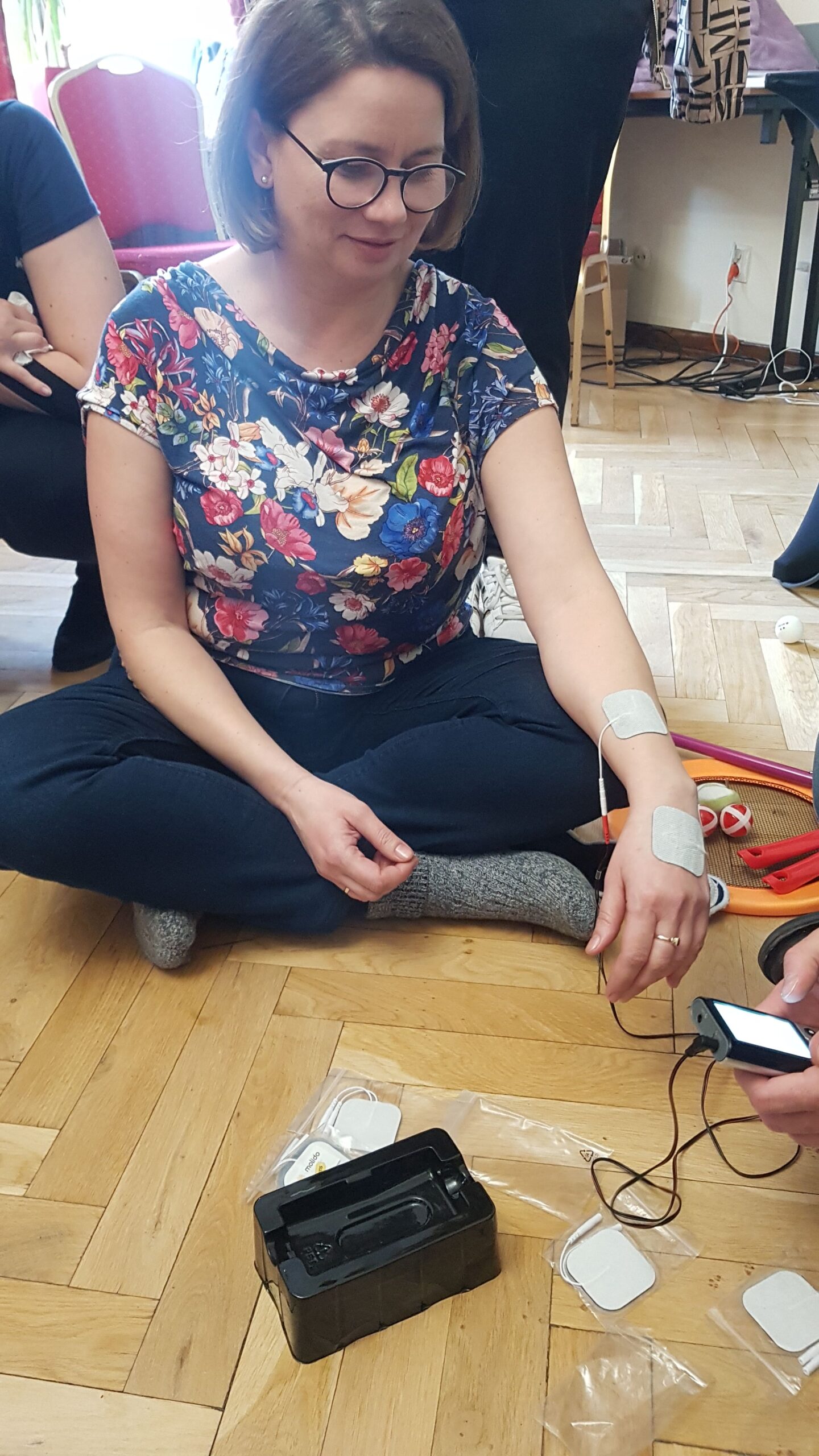 Pani Monika podczas nauki przeprowadzania elektrostymulacji ręki.