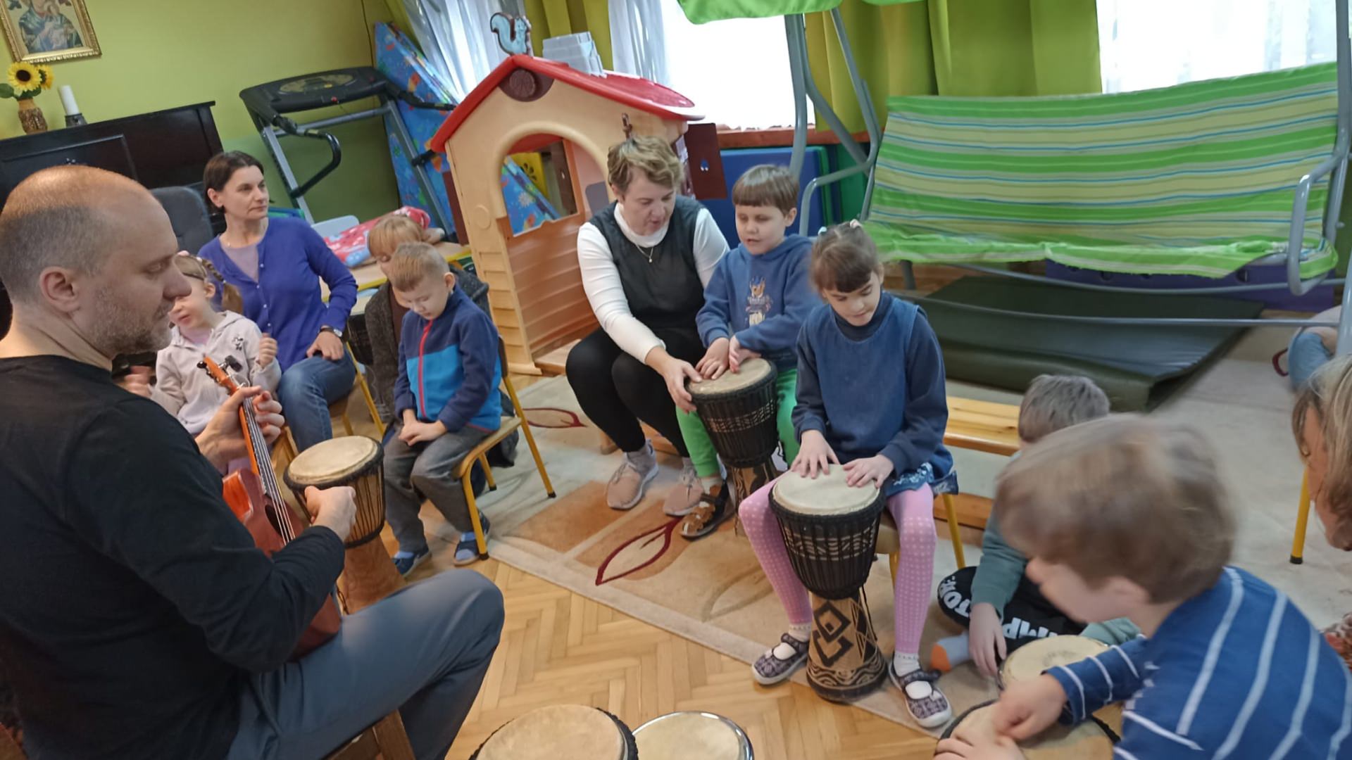 Dzieci grają na bębnach, a pan Michał na ukulele