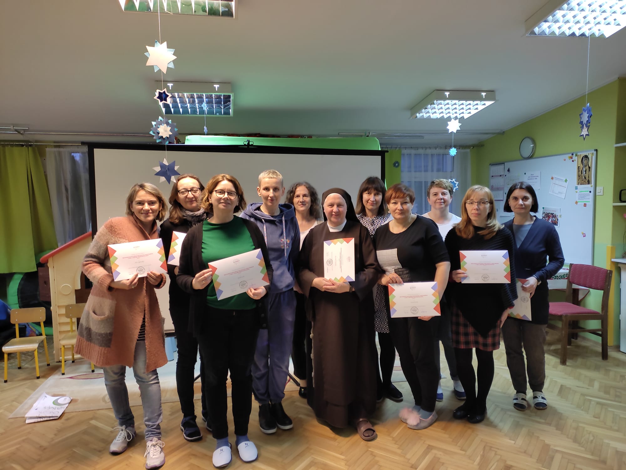 Prowadząca szkolenie p. Monika Jerzyk i grupa nauczycieli przedszkola z dyplomami w dłoniach.