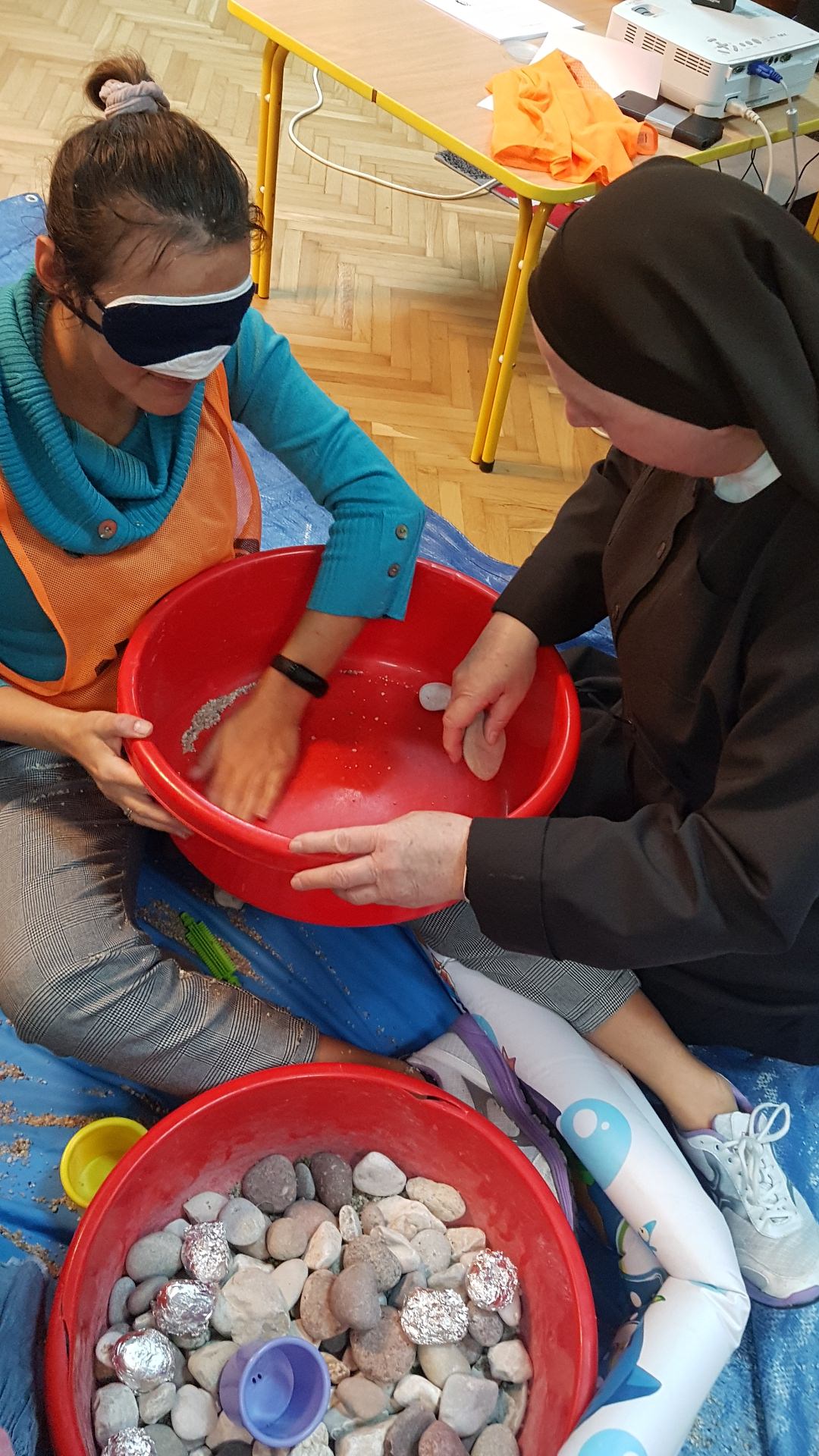 Siostra Julitta pomaga pani będącej w opasce na oczach oglądać kamienie.