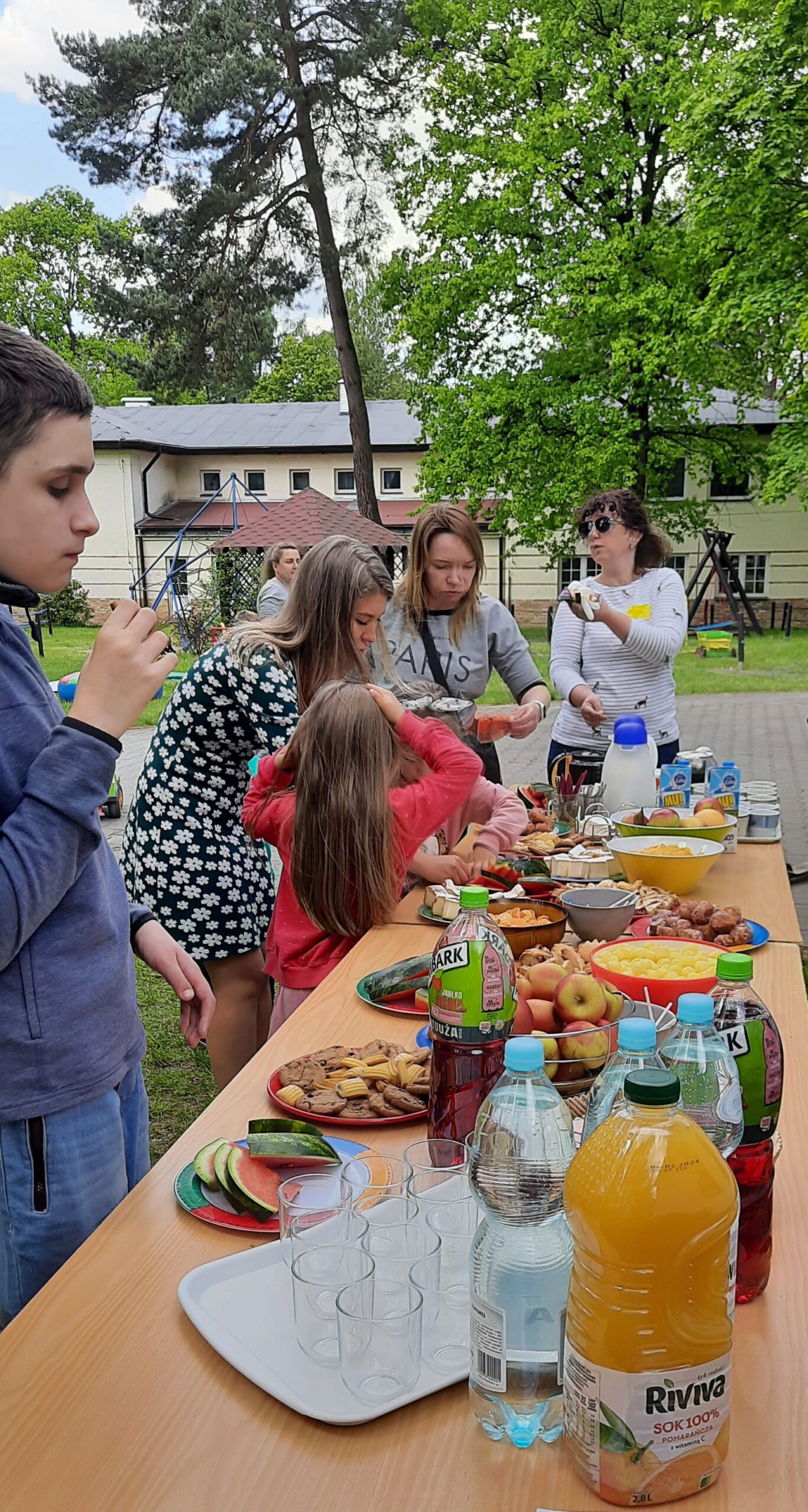 Chwila na poczęstunek. Na stole są ciastka, napoje i kanapki.