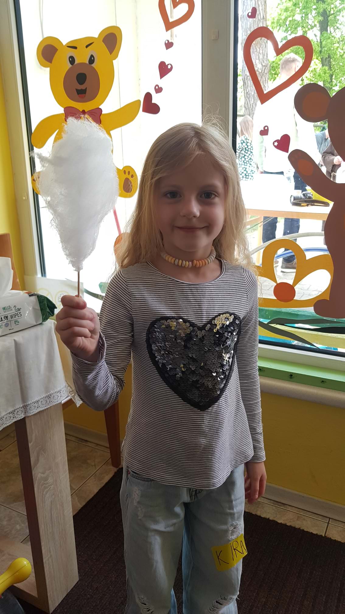 Dziewczynka trzyma w ręku watę cukrową.