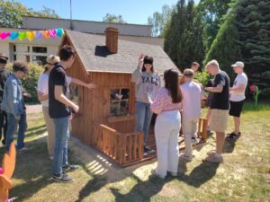 Uczniowie liceum zwiedzają domek z zasłoniętymi oczami.