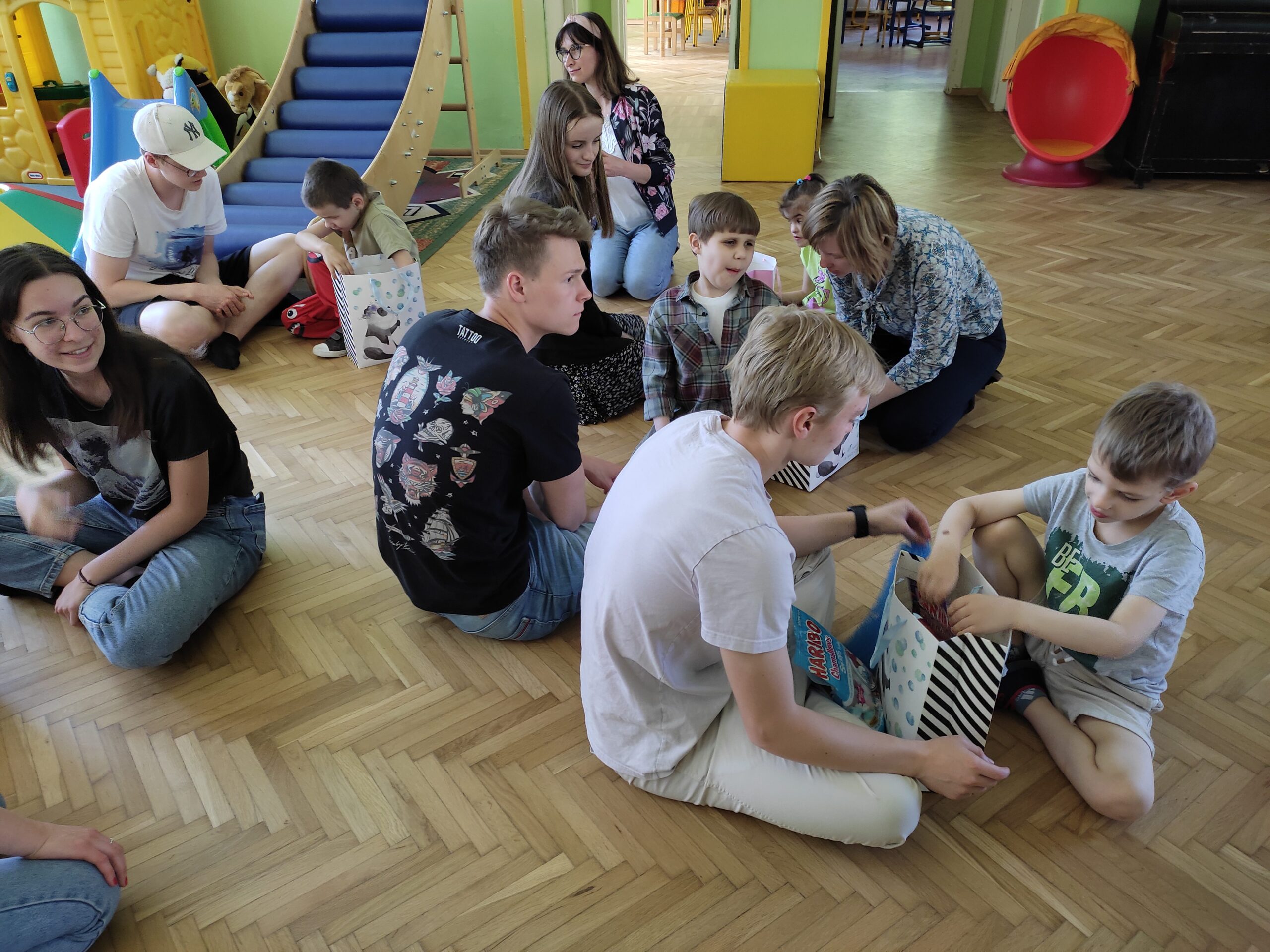 Dzieci oglądają prezenty otrzymane od licealistów.