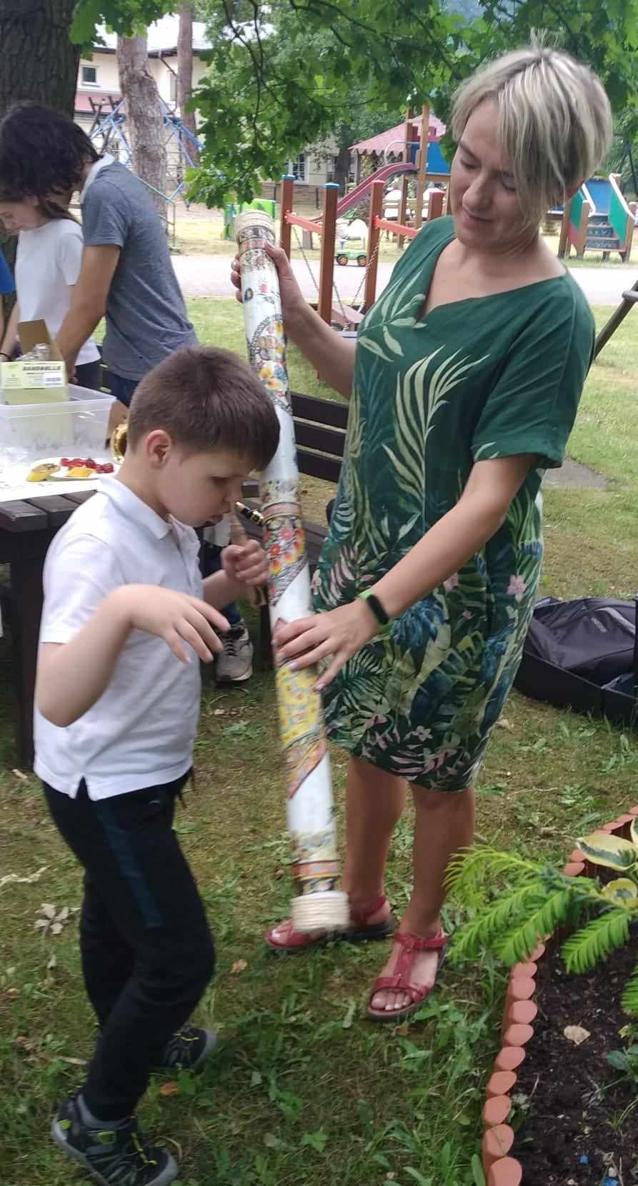 Chłopiec słucha dźwięków wydawanych przez rainstick.