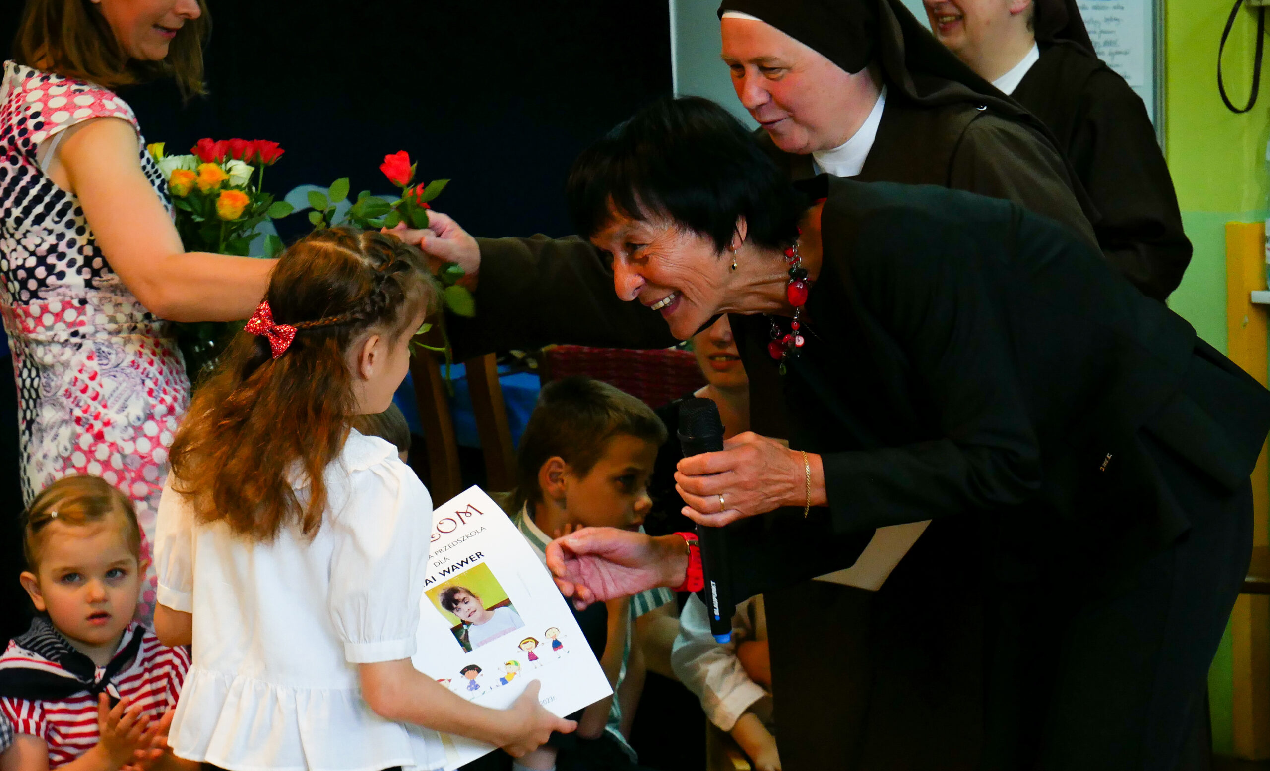 Pani Elżbieta Szczepkowska wręcza dyplom dziewczynce.