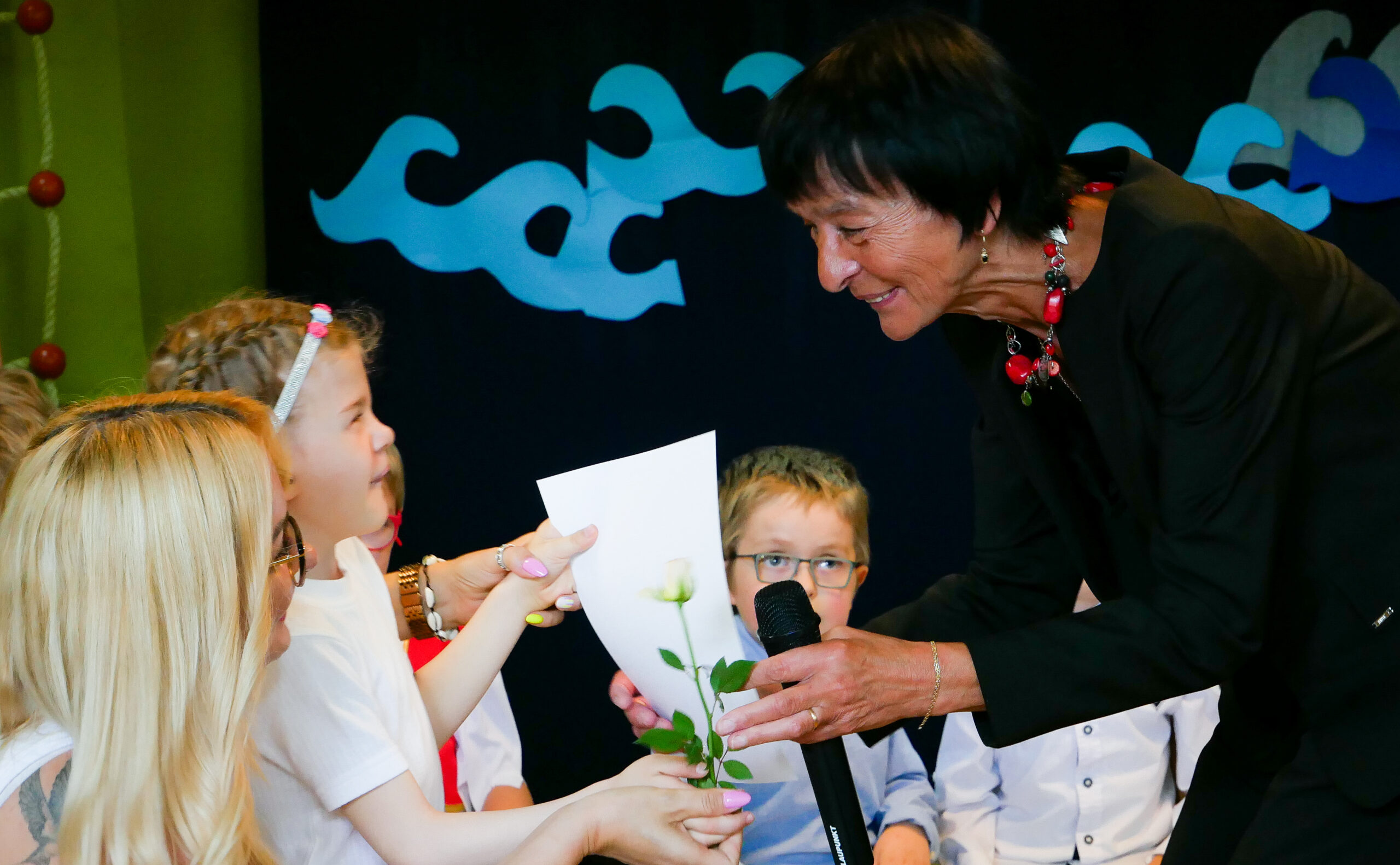 Pani Elżbieta Szczepkowska wręcza dyplom dziewczynce.
