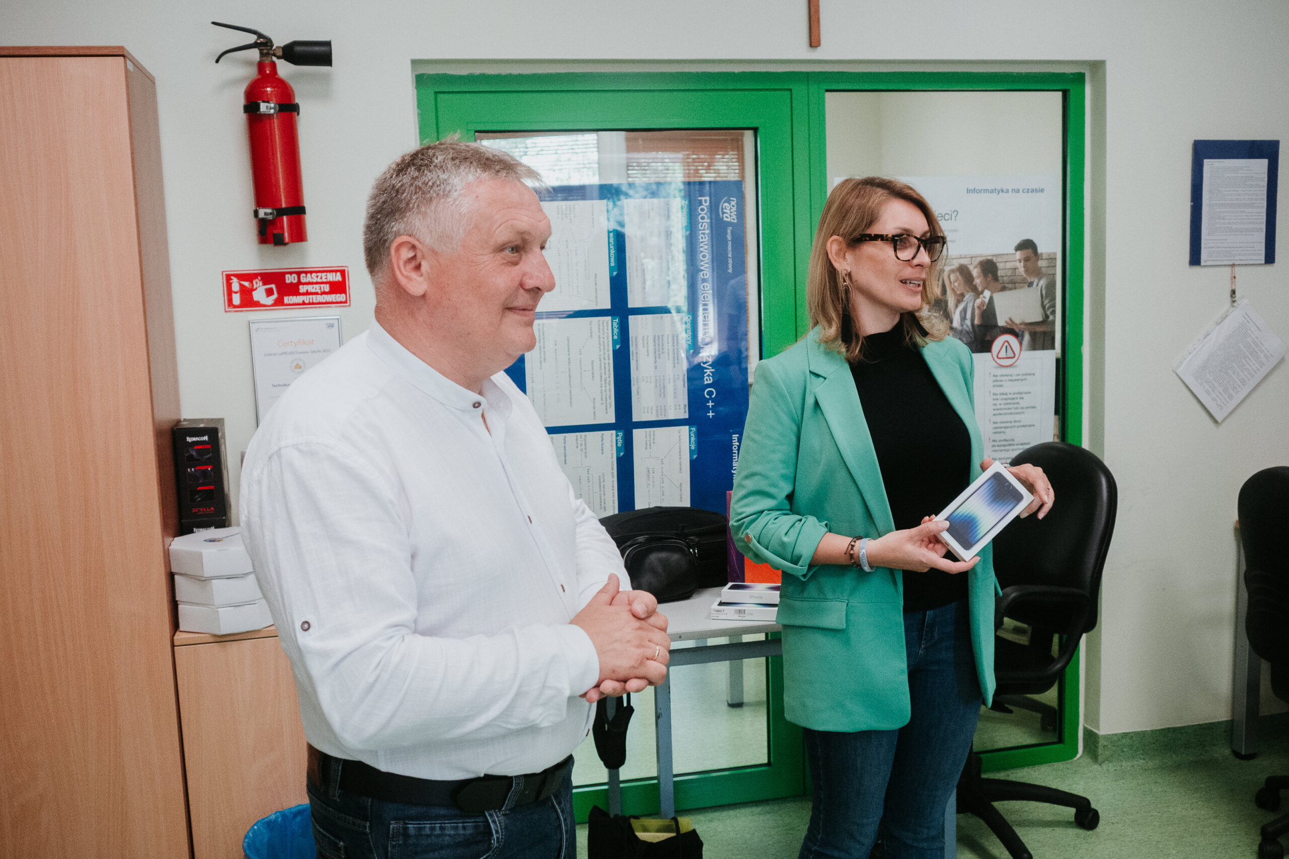 Piotr Dziuba i Kamila Miler-Zdanowska trzymają telefony w rękach.