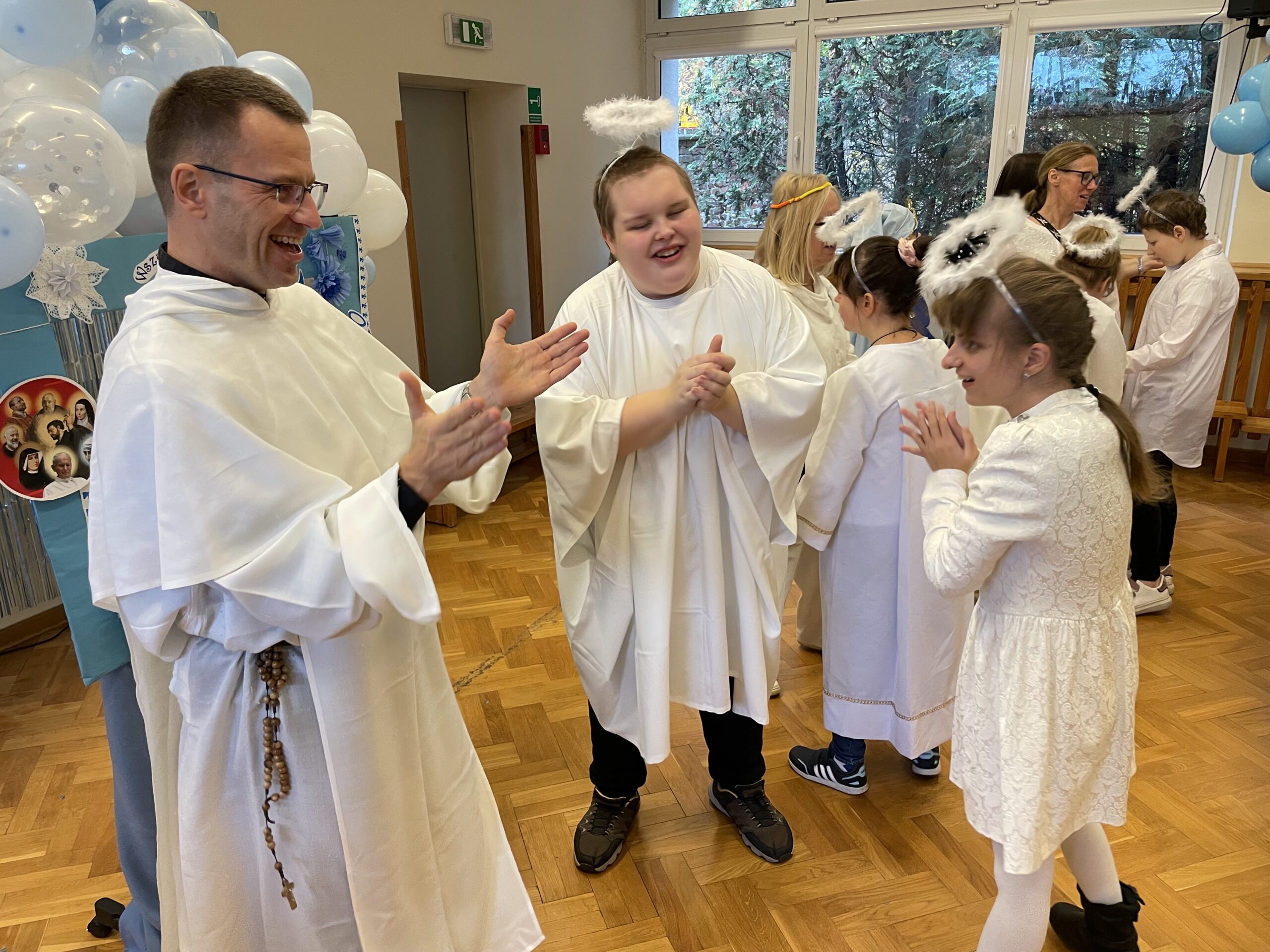 Ksiądz Marek z uczniami przebranymi za anioły.