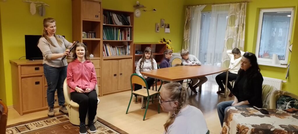 Pani fryzjerka tworzy loki na głowie Pauliny