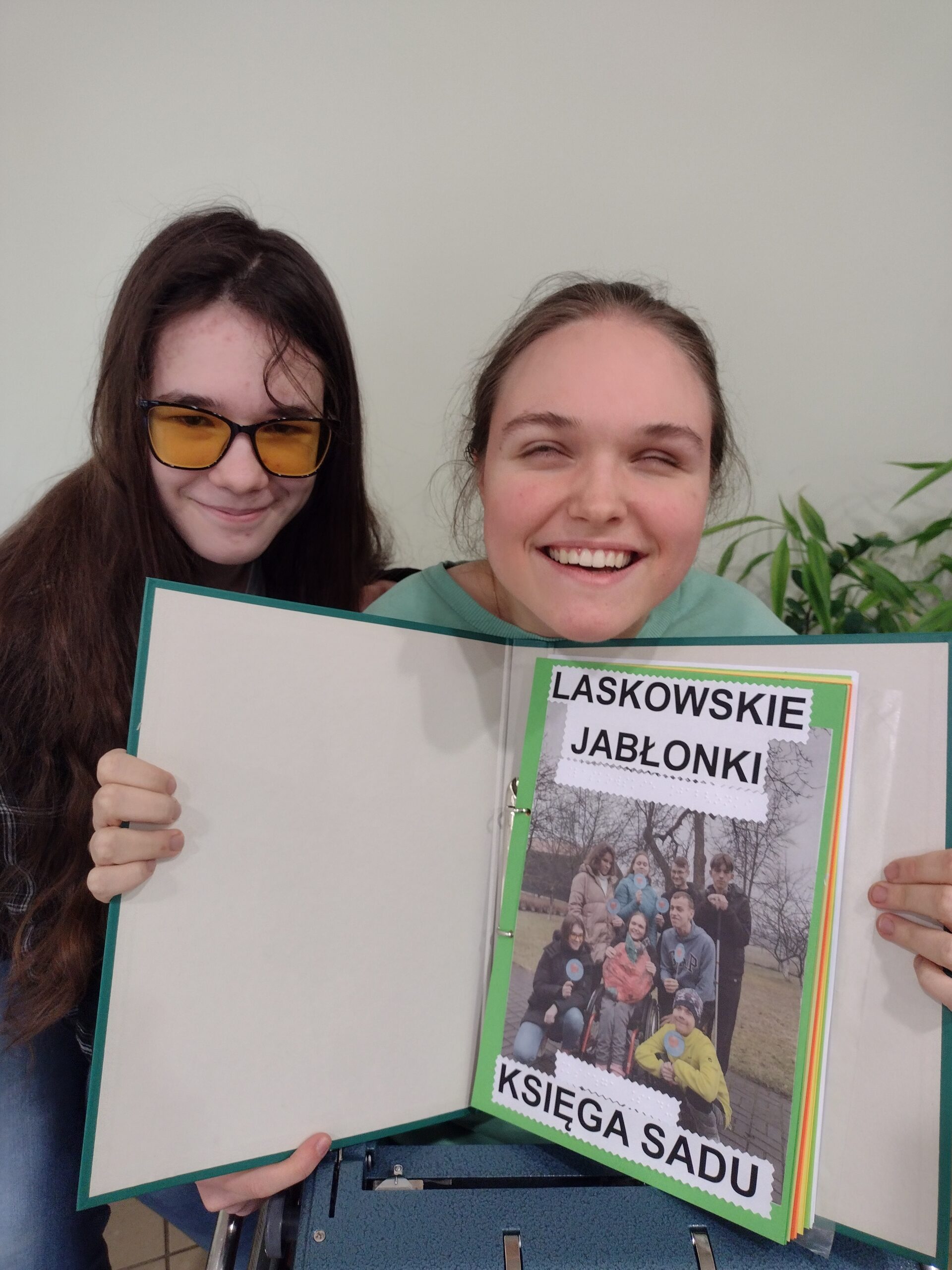 Uczennice pokazują księgę projektu.