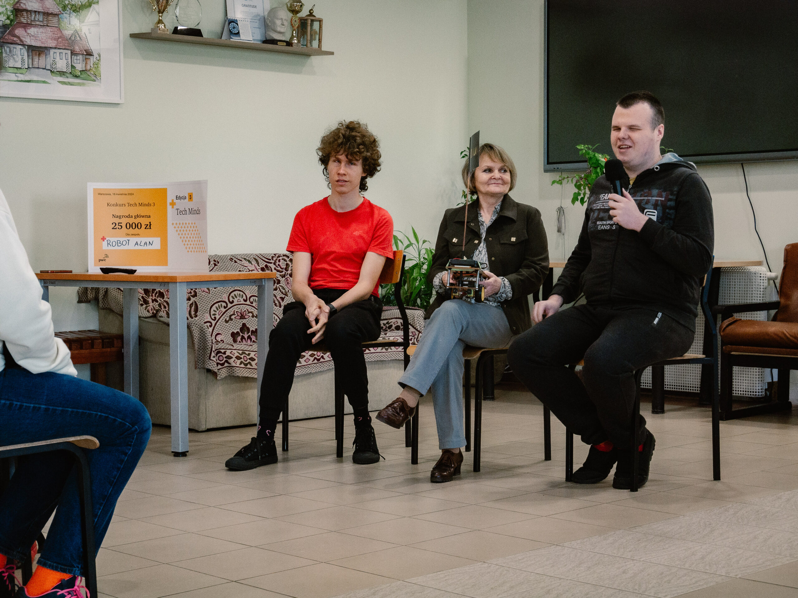 Pani Hania, Maciek i Klaudiusz opowiadają o przygotowaniach do konkursu swoim kolegom w szkole.