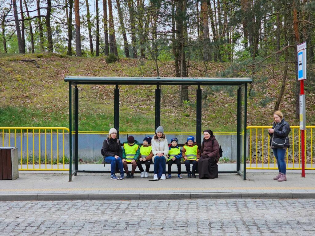 Zuchy siedzą na ławce na przystanku autobusowym w Laskach.