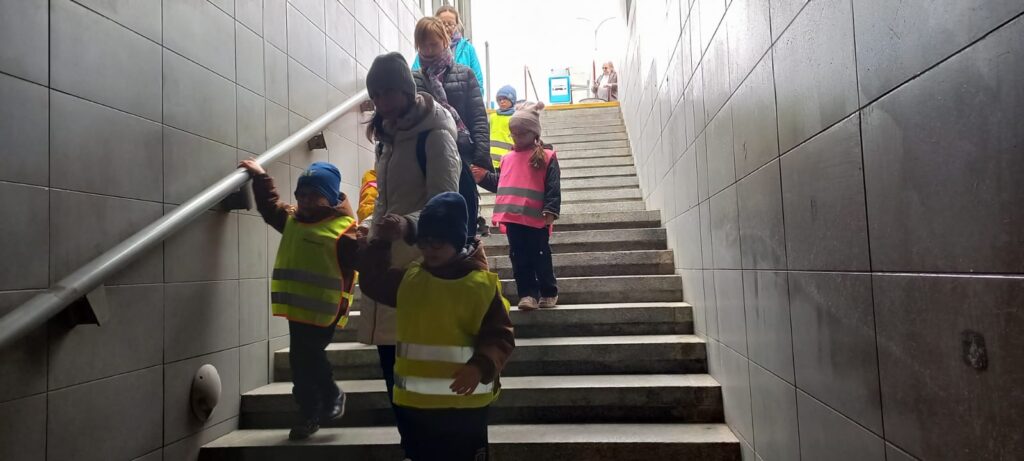 Przedszkolaki schodzą schodami do metra.