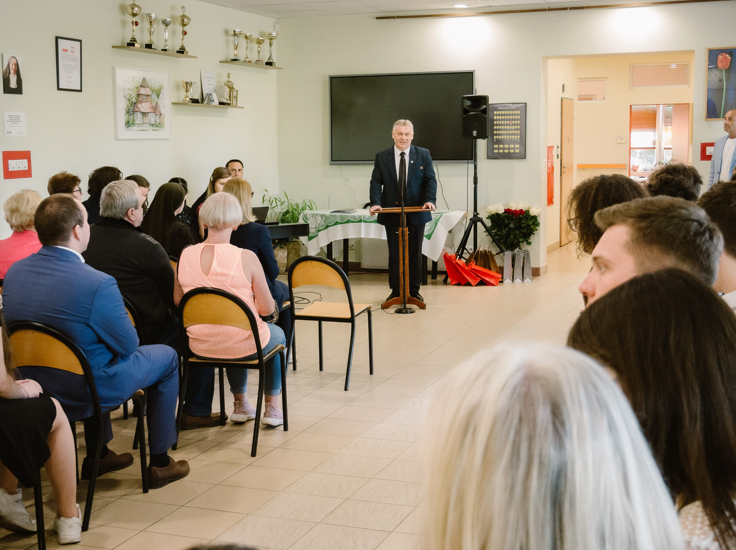 Dyrektor Piotr Dziuba wita zebranych w holu szkoły.