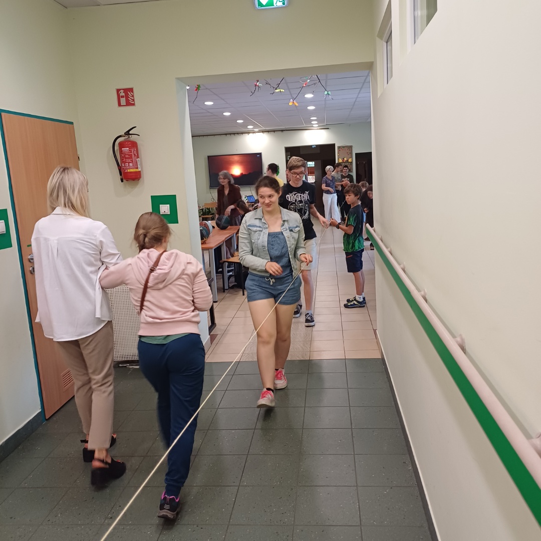 Uczniowie mierzą odległość za pomocą sznurka.