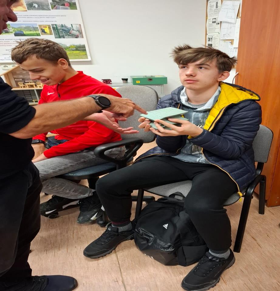 Uczniowie oglądają modele reaktora jądrowego.