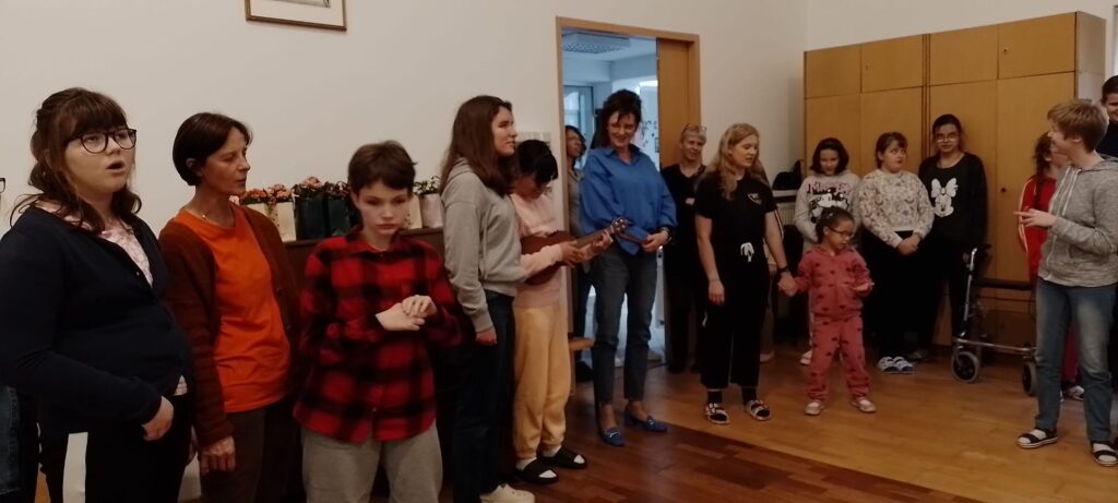 Hathi gra na ukulele a pozostali uczestnicy śpiewają 100 lat
