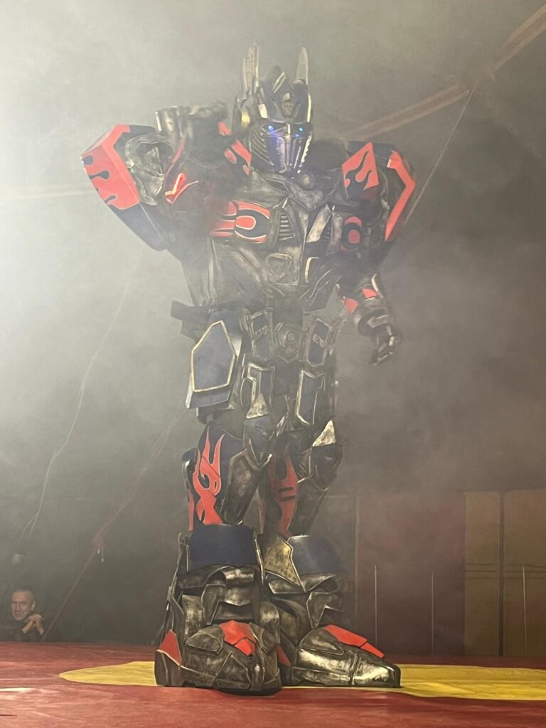 Transformer w czarno - czerwonym stroju na scenie