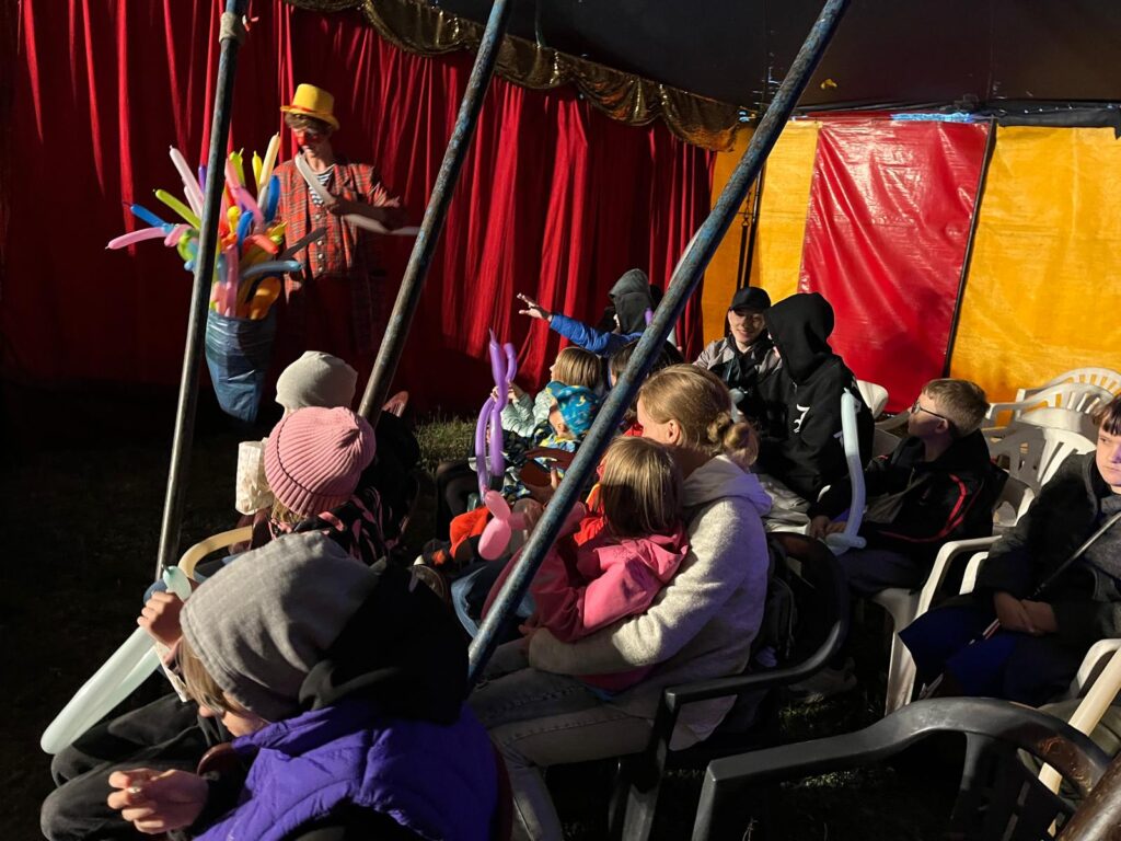 Klaun rozdający uczestnikom długie balony