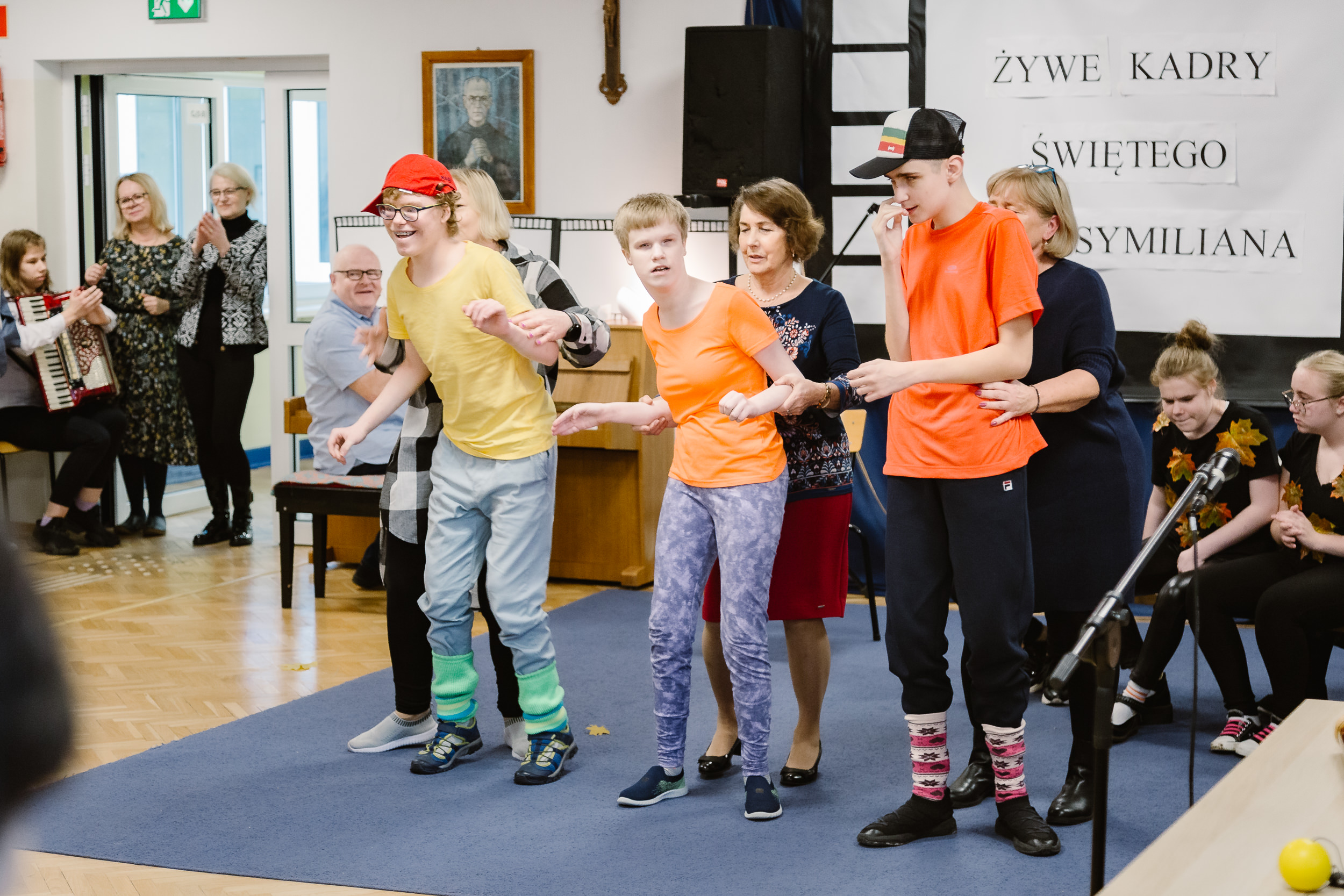 Uczniowie w sportowych strojach tańczą z wychowawcami.