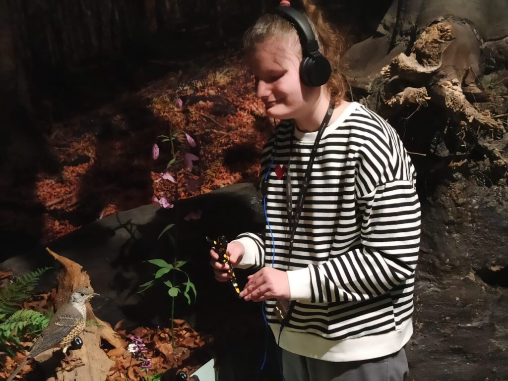 Sandra trzyma w ręku  eksponat salamandry plamistej -symbolu Gorczańskiego Parku