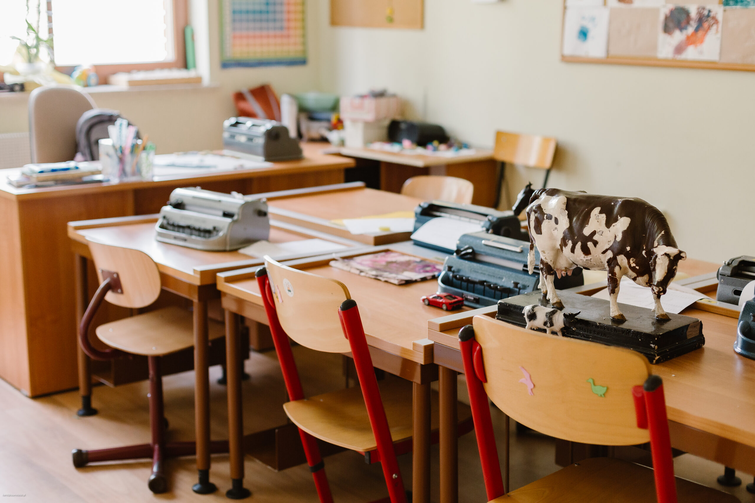 Widok na ławki szkolne z tornistrami, książkami itd. 