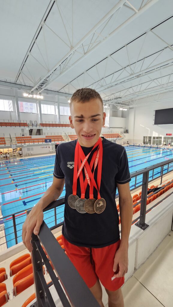 Chłopiec z 4 medalami na szyi
