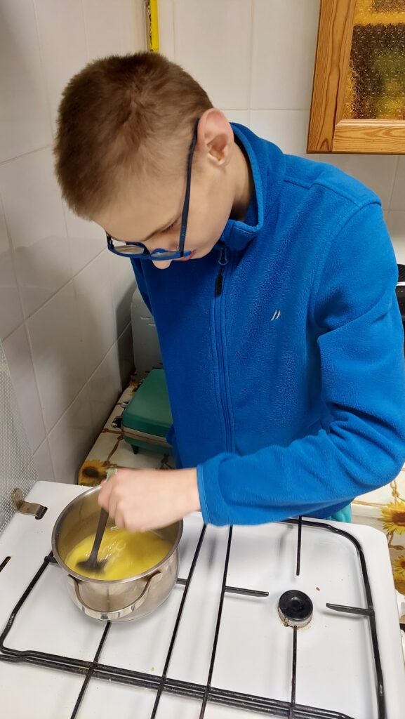 chłopiec miesza łyżką w garnku