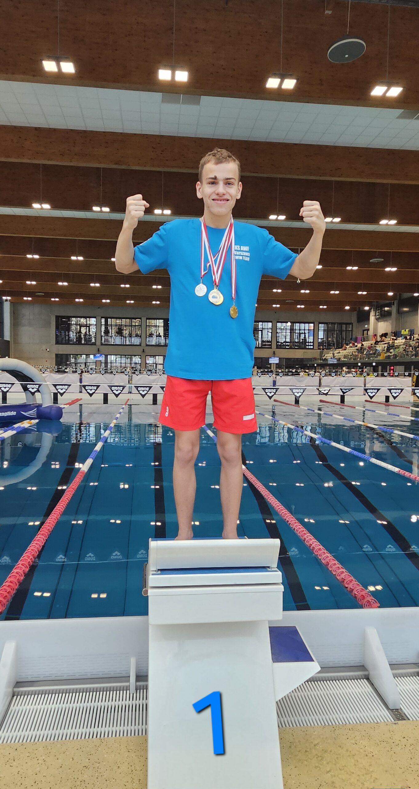 Alex na podium z medalami na szyi.