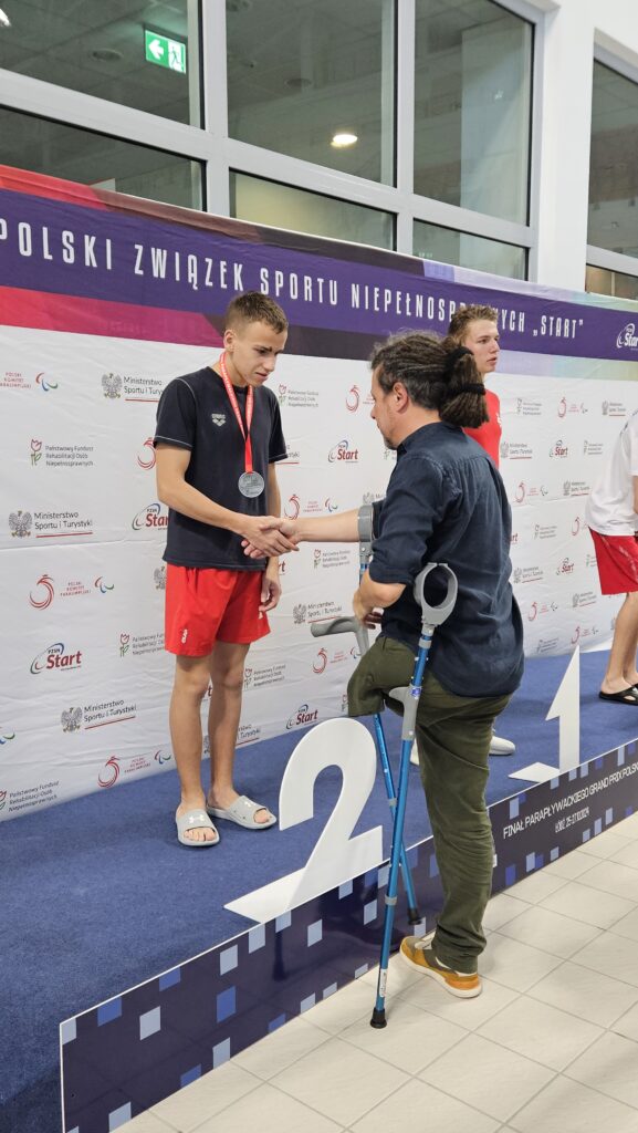 Chłopiec na podium przyjmuje gratulacje