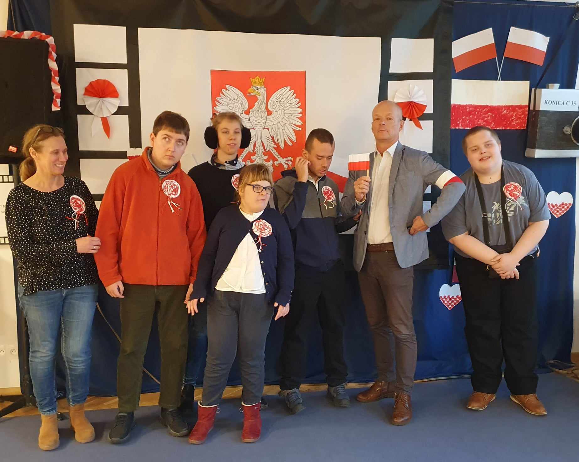Pan Dyrektor w towarzystwie uczniów szkoły pod flagą Polski