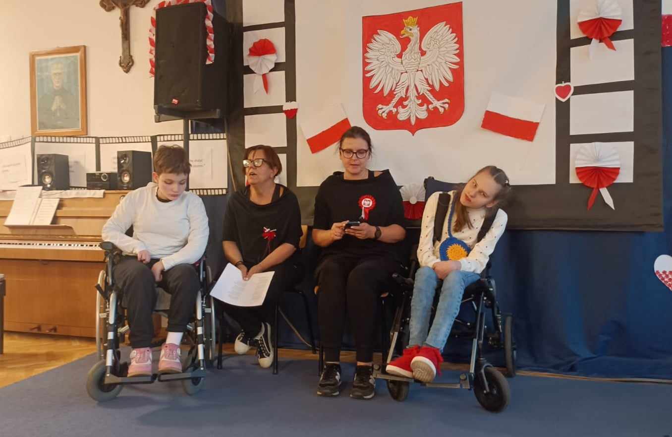klasa piąta z nauczycielami pod dekoracją patriotyczną