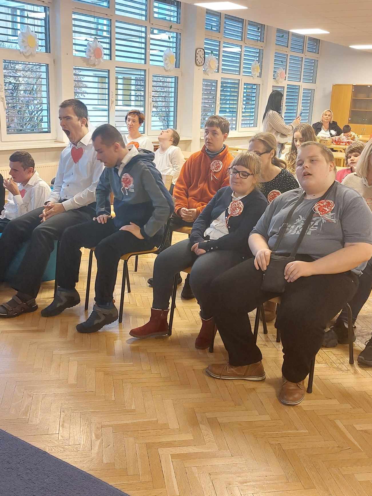 Uczniowie zebrani na szkolnym holu w oczekiwaniu na uroczystość