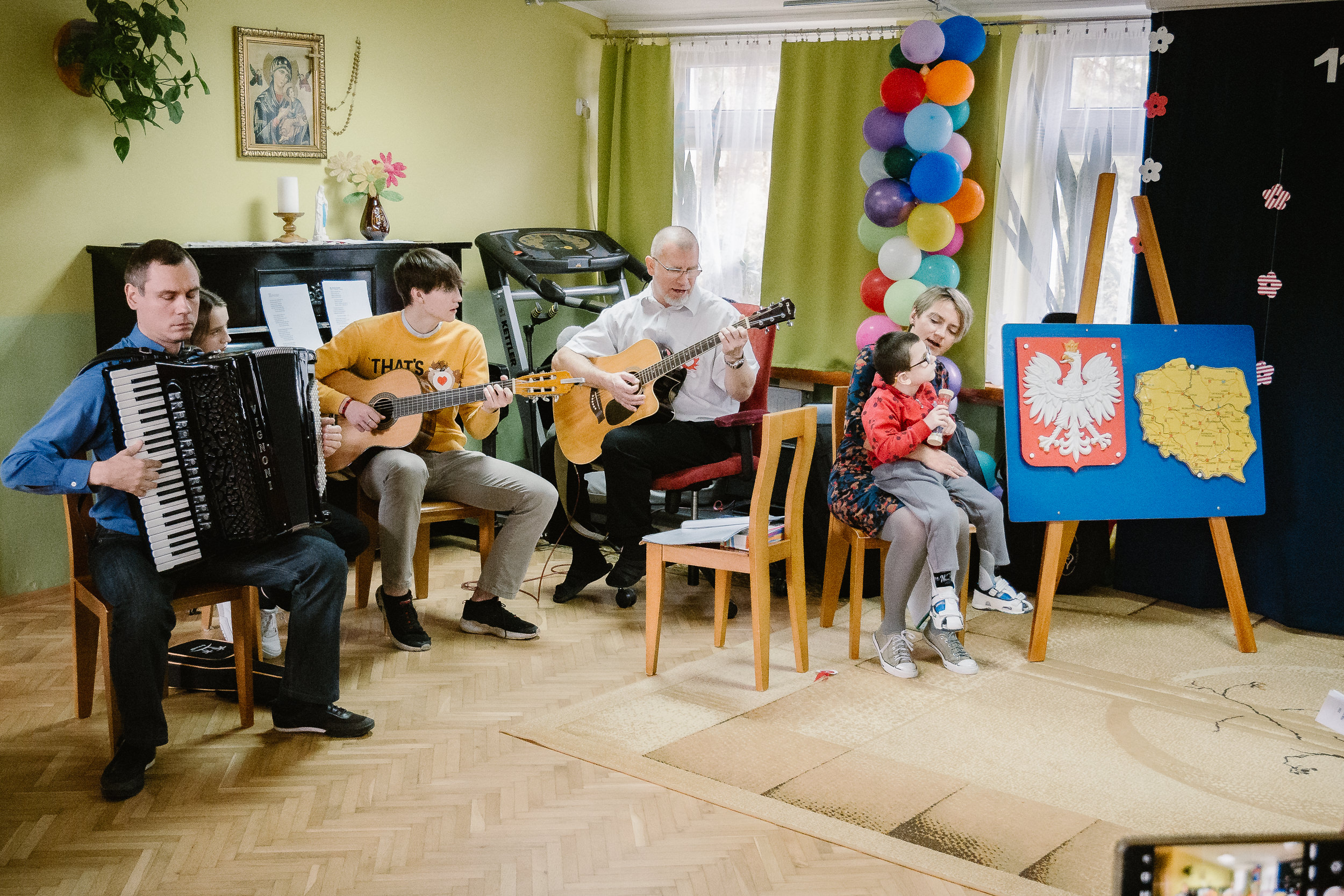 Opiekunowie grają na akordeonie i gitarach.