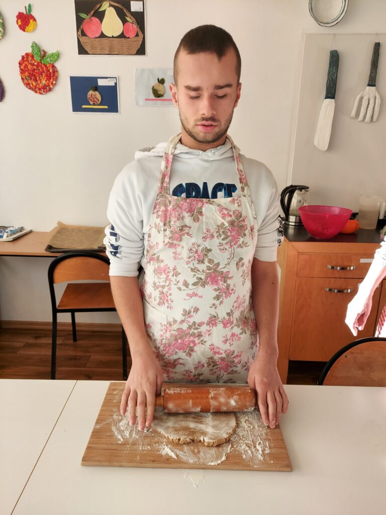 Miłosz wałkuje ciasto na stolnicy