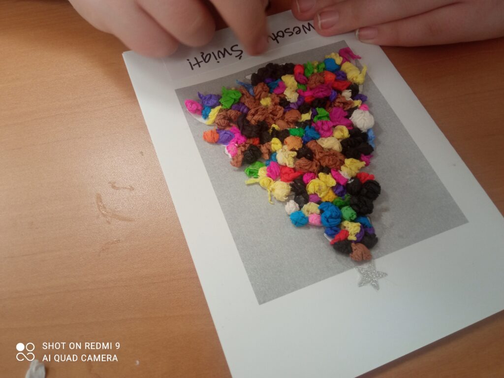 Rafał przykleja napis "Wesołych Świąt"