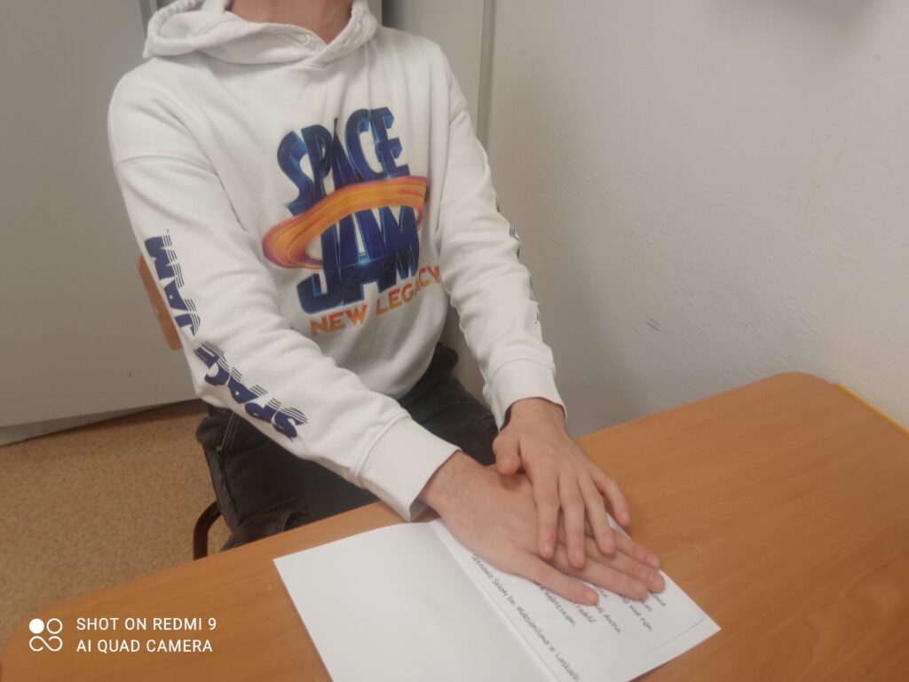 Miłosz przykleja  życzenia na kartkę