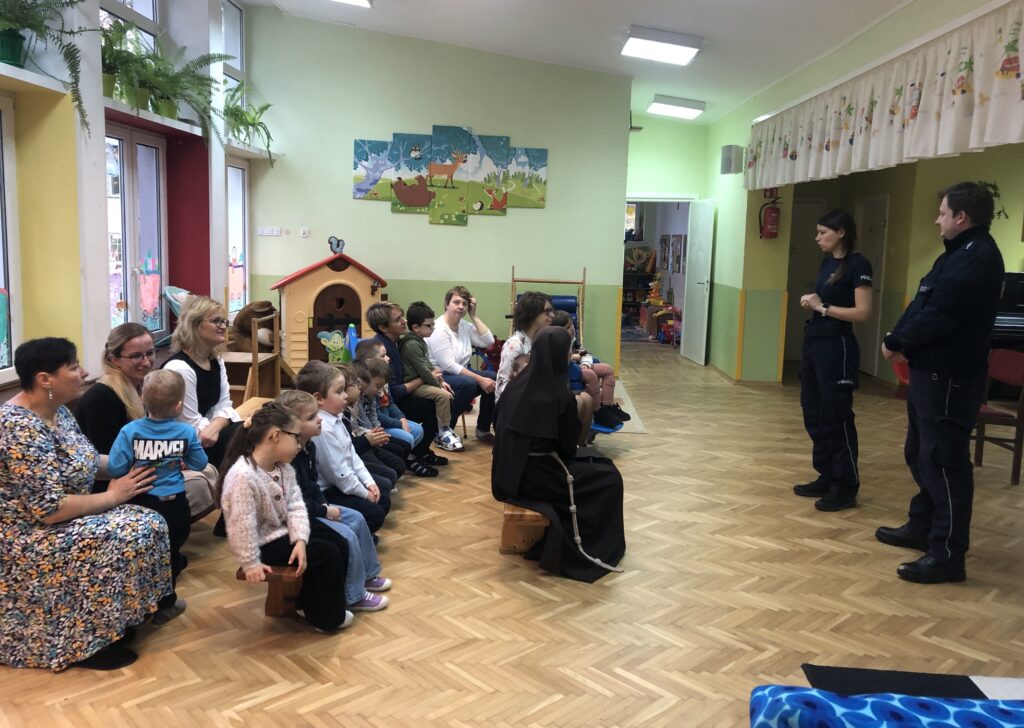 Dzieci i nauczyciele słuchają policjantów