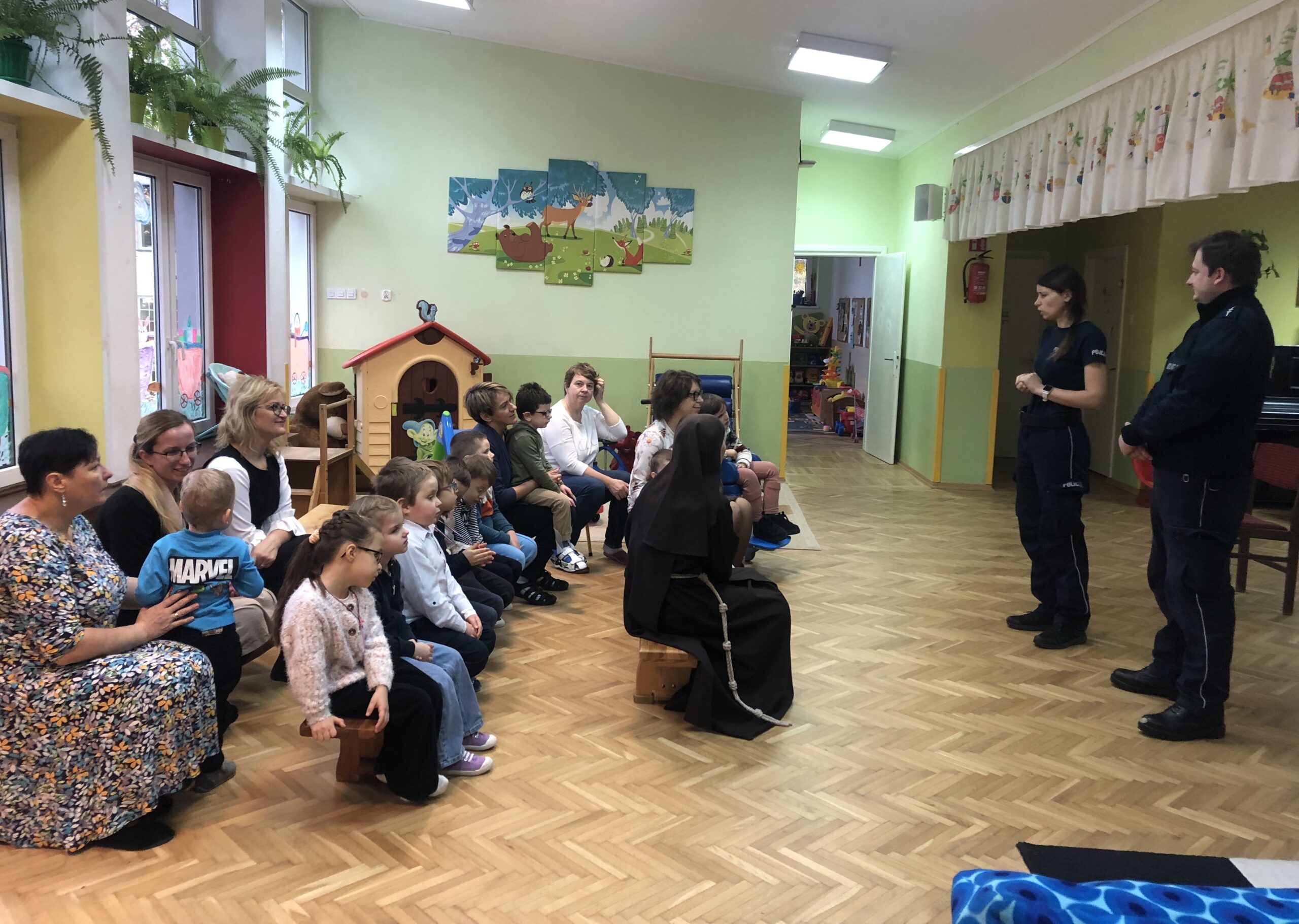 Dzieci i nauczyciele słuchają policjantów