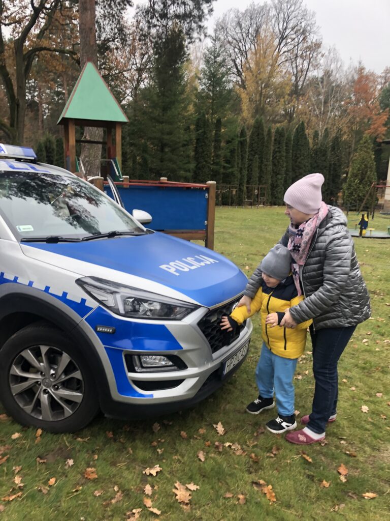 Chłopiec z nauczycielką ogląda radiowóz