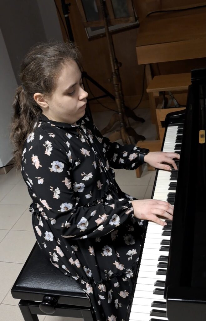 Amina Romas przy fortepianie