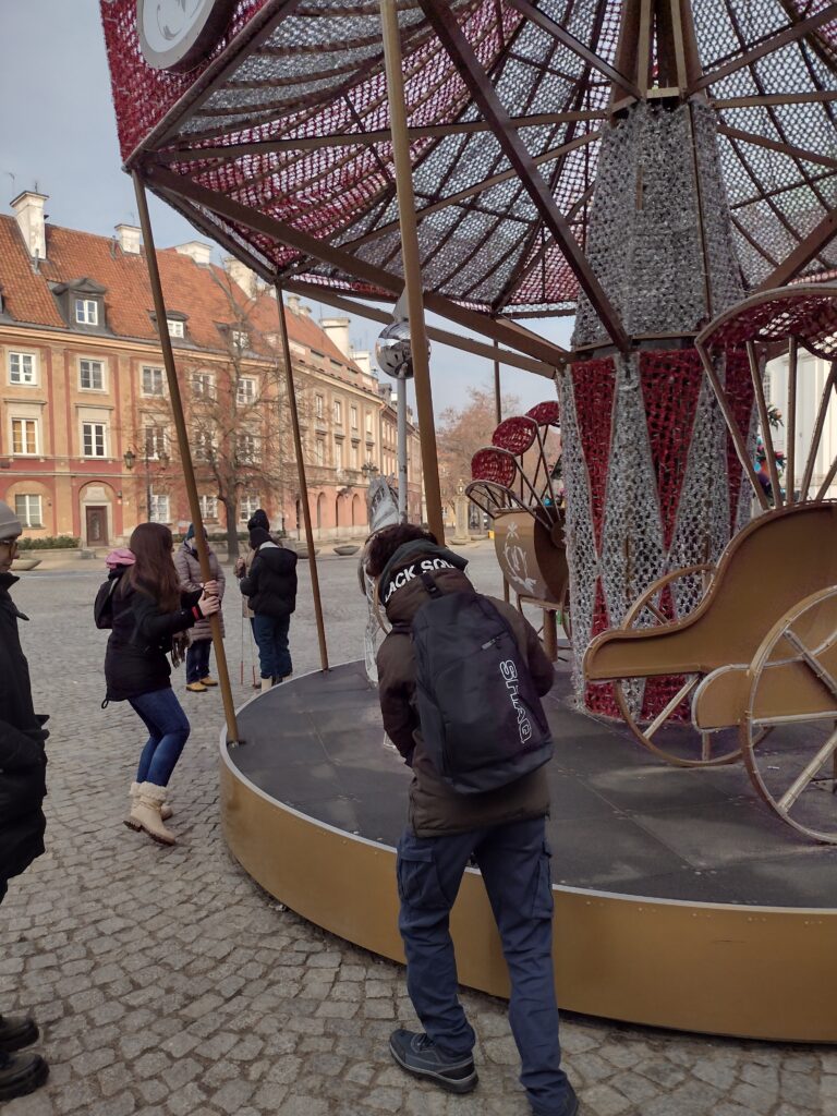 Karuzela świąteczna na starówce. Uczniowie kręcą karuzelą.