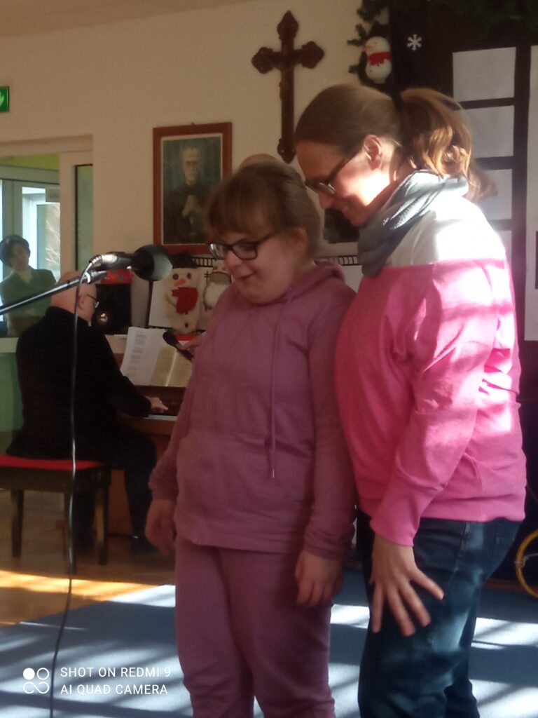 Ola stoi przy mikrofonie i śpiewa. Towarzyszy jej pani Renata