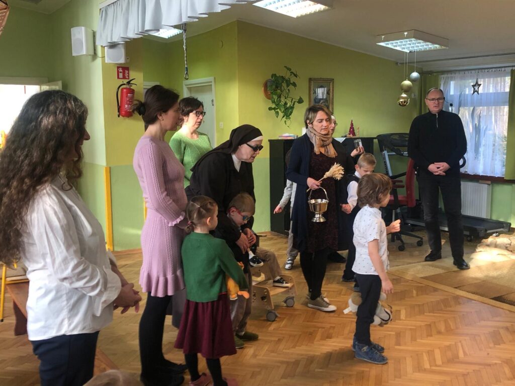 Dzieci i pracownicy przedszkola modlą się na bawialni