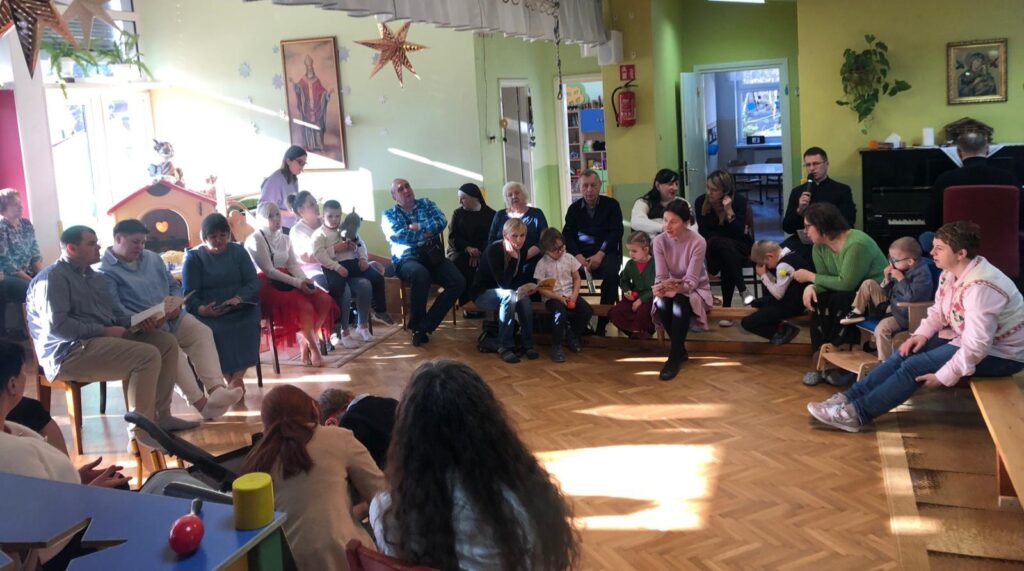 zdjęcie grupowe, dzieci i dorośli siedzący na ławkach i krzesłach