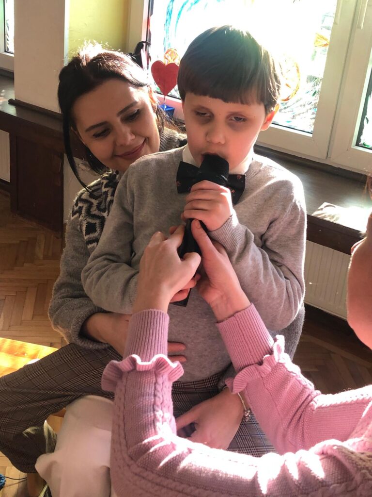 Chłopiec z mamą śpiewa do mikrofonu